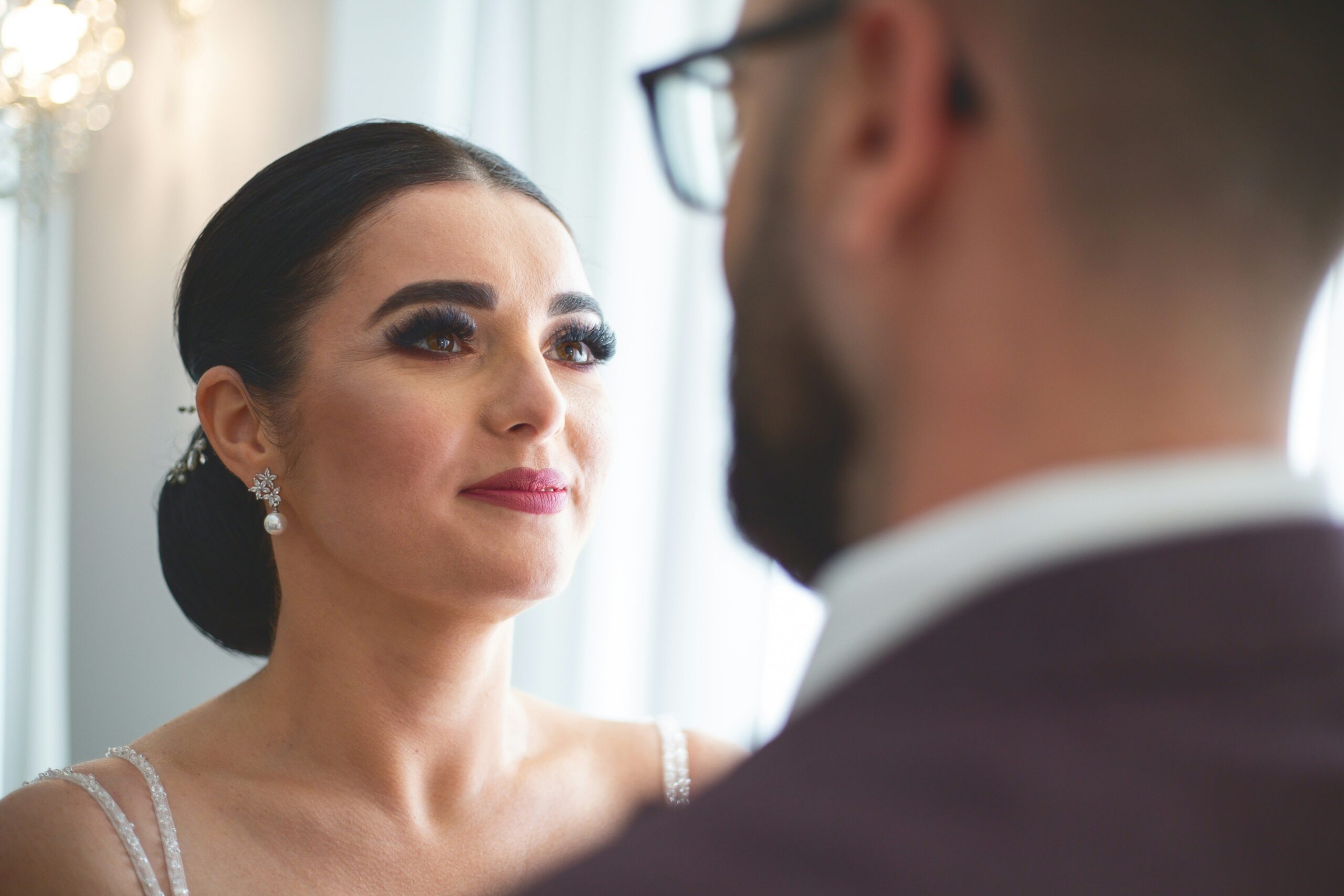 A beautiful bride posing outdoors with glowing makeup and radiant skin