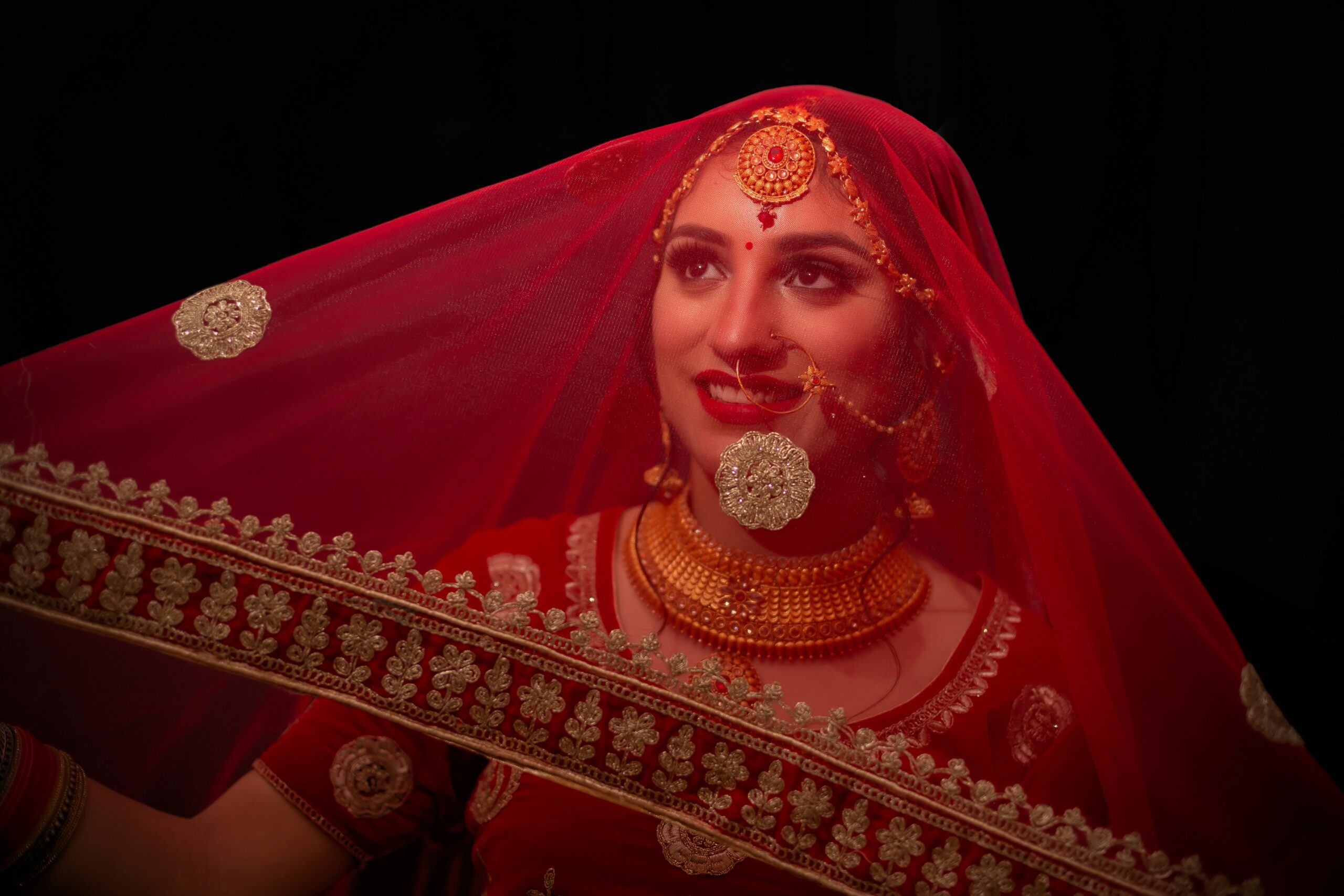 A bride smiling confidently with flawless makeup under soft lighting