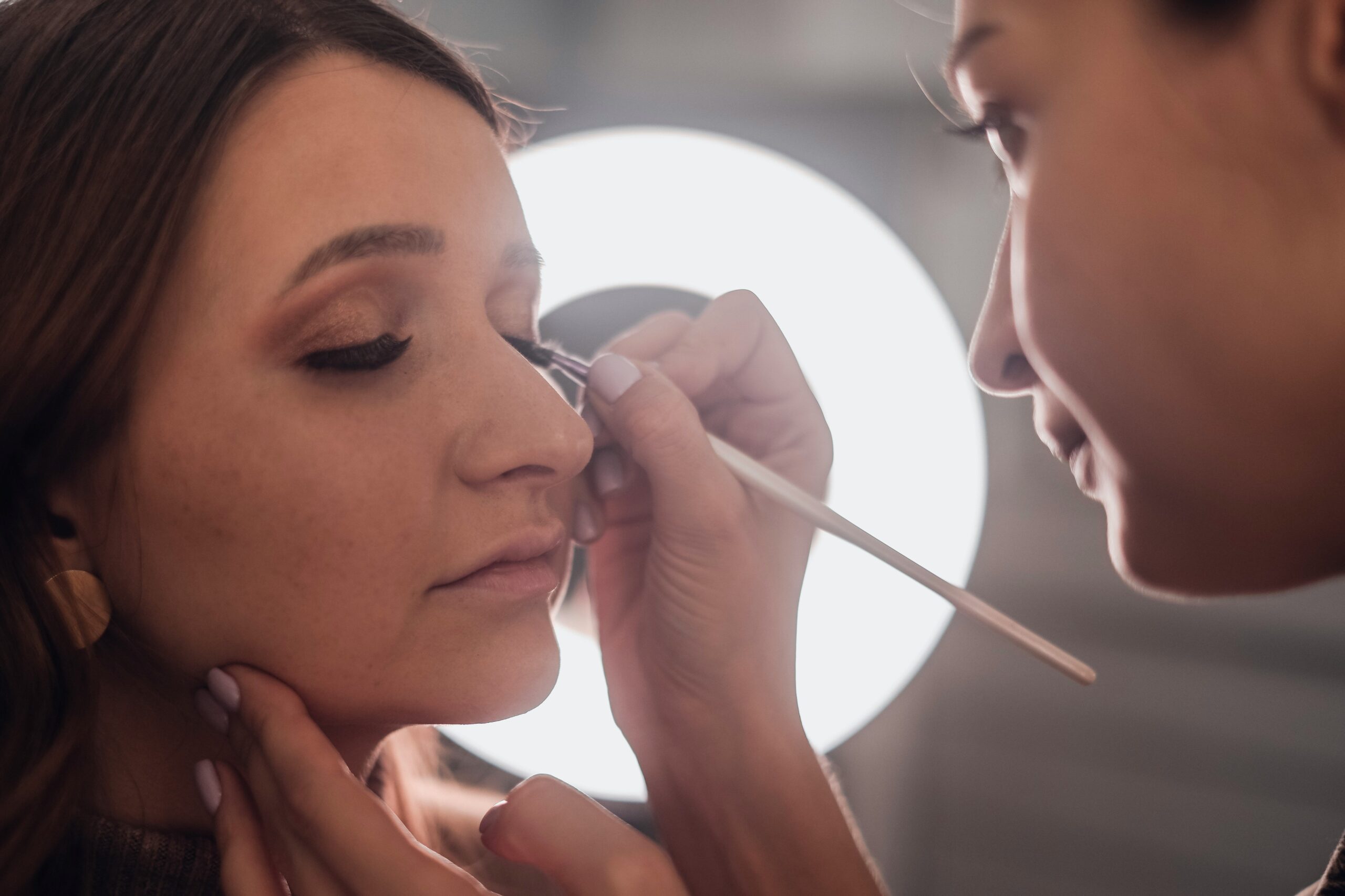 A professional makeup artist applying foundation to a bride's face