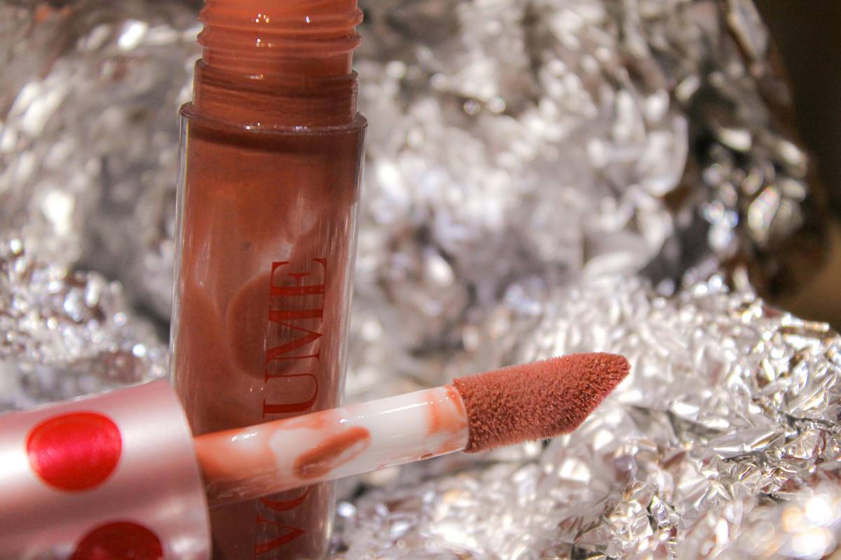 Close-up image showcasing layered makeup steps, including foundation, eyeshadow, and lipstick application.