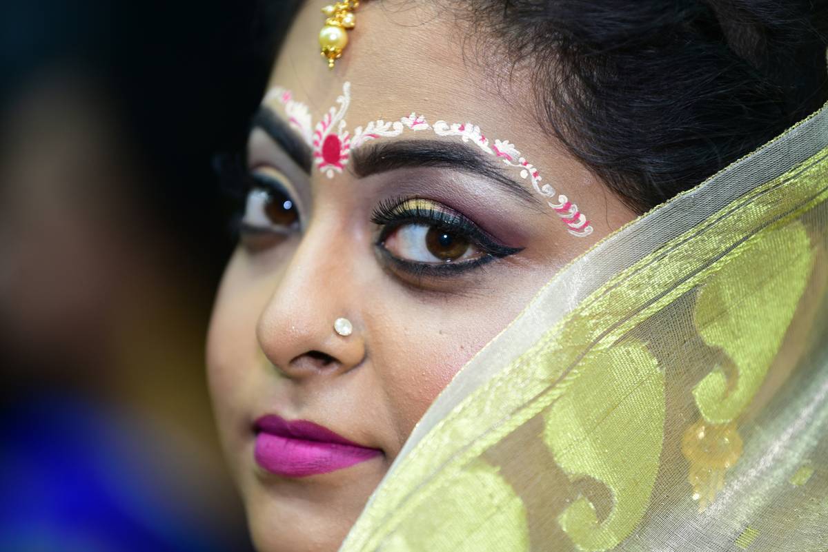 A bride touching her cheek showing signs of flaky skin in winter.