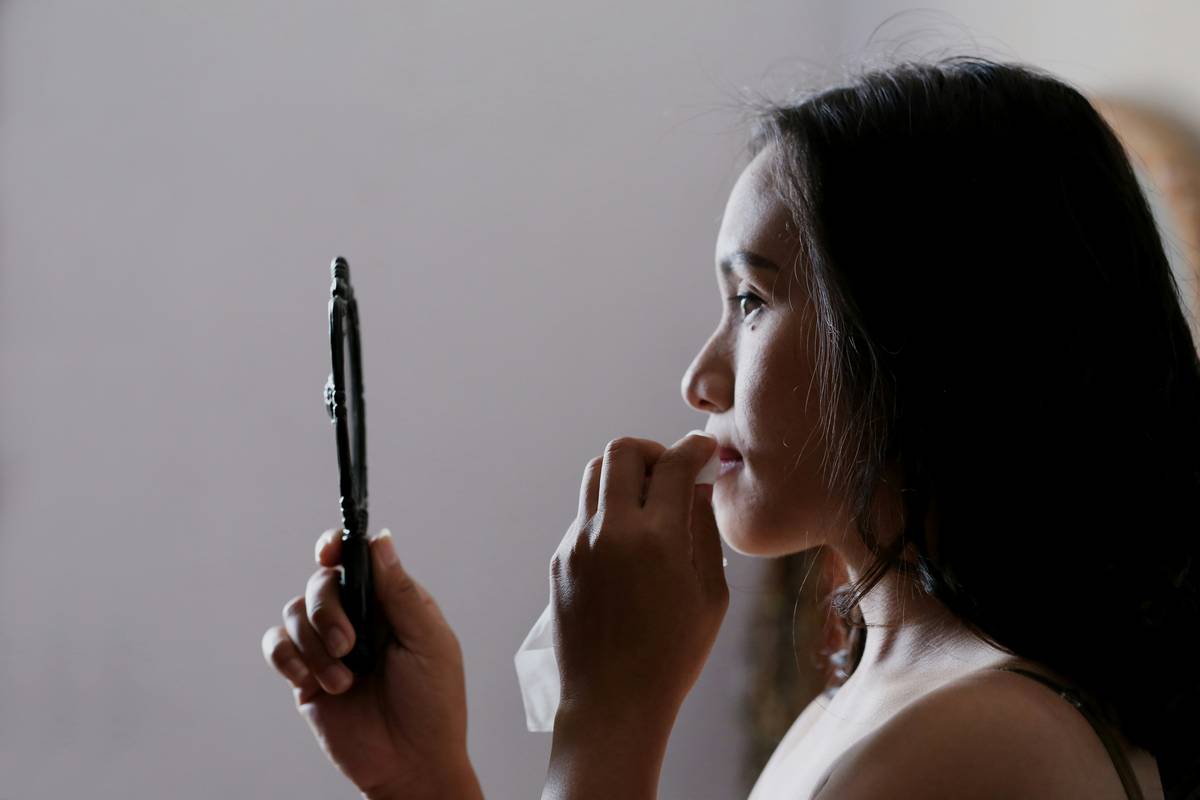 A bride using a wedding makeup remover product on her face after the big day