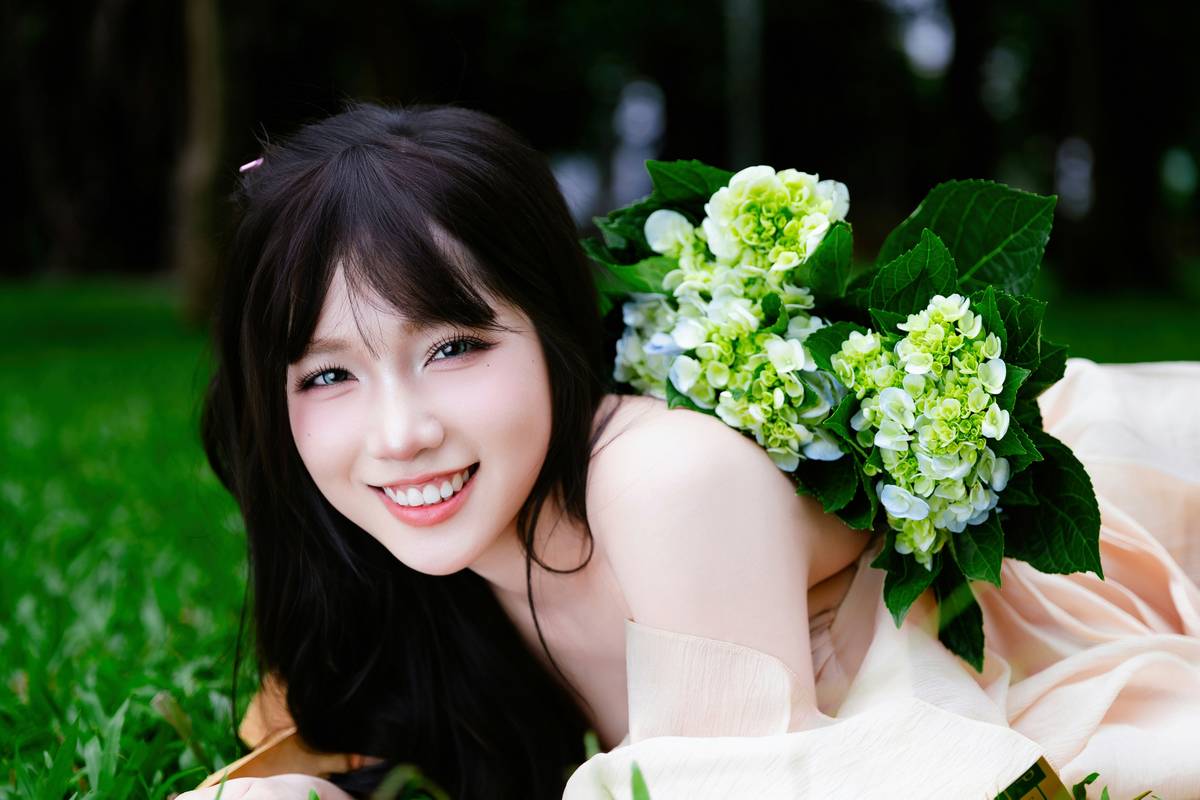 A smiling bride under a summer sun wearing glowing bridal makeup