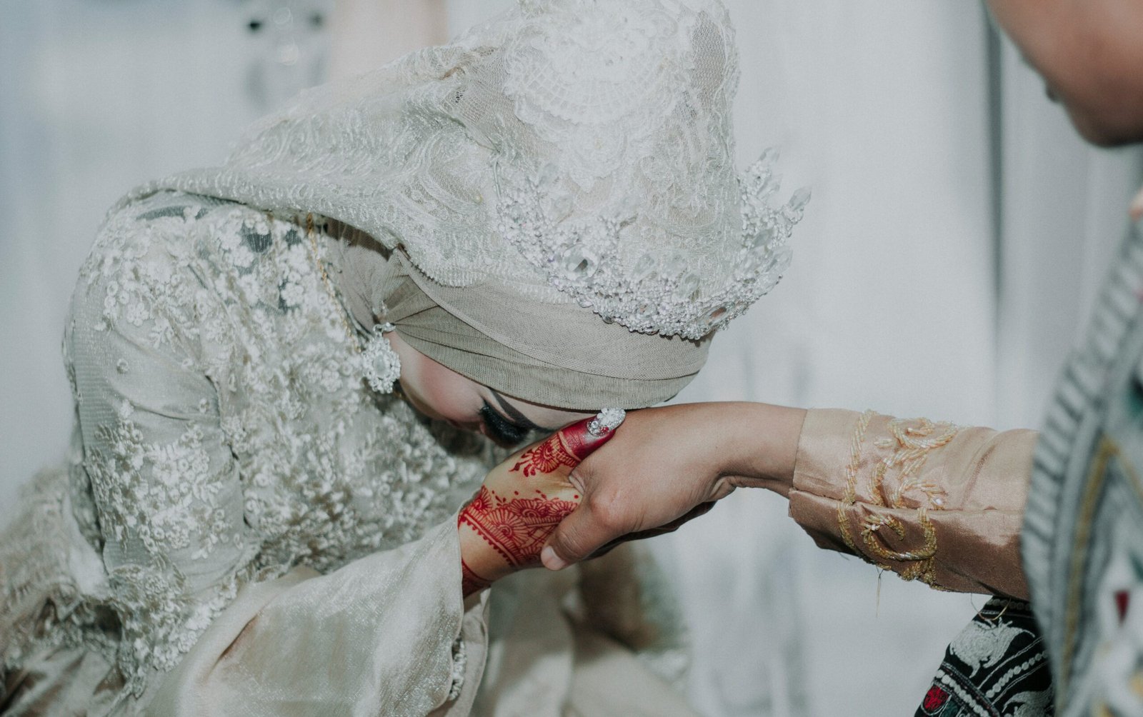 woman in gray and white floral wedding dress holding a person's right hand