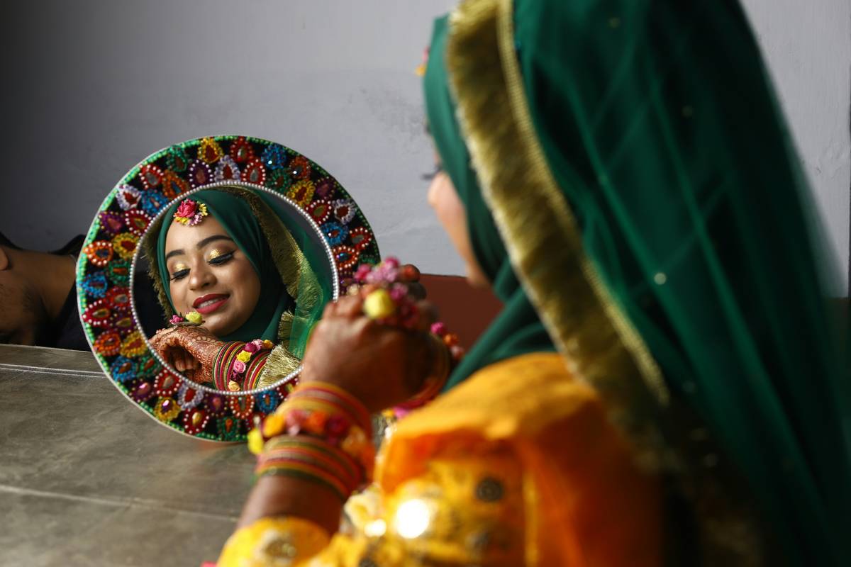 A bride applying foundation on her mature skin using a damp sponge