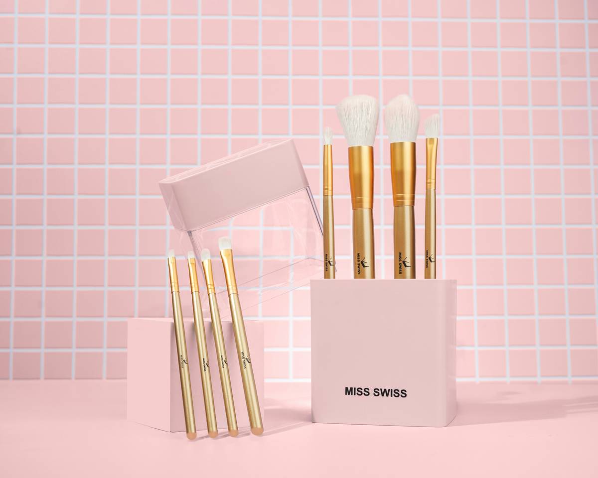 A white acrylic organizer filled with makeup brushes, lipsticks, and skincare essentials.