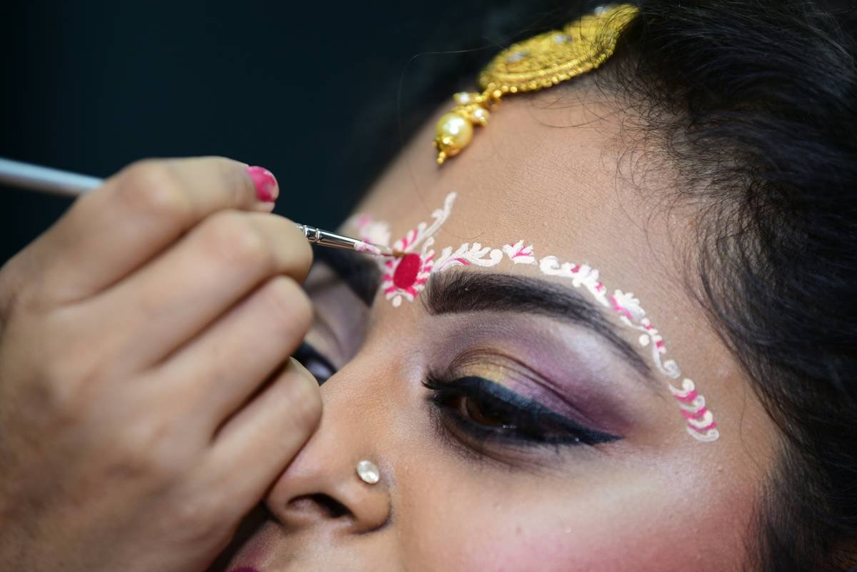 A woman applying waterproof foundation for a bridal event