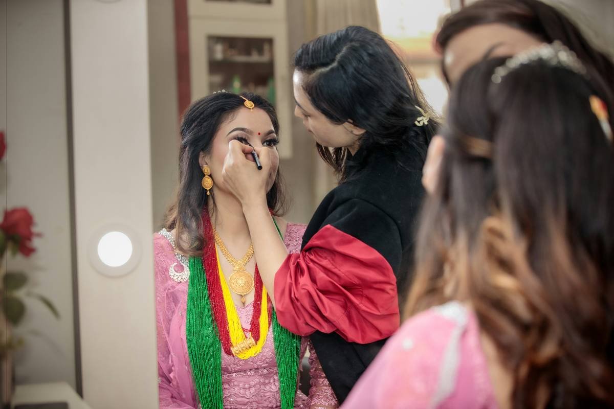 A student practicing bridal makeup techniques during a professional course.