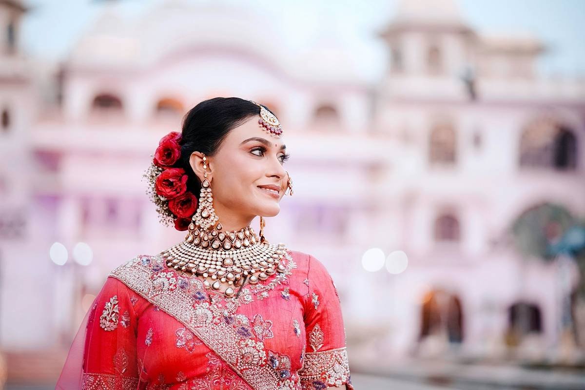 Chart comparing ceremony vs reception lighting conditions and recommended makeup adjustments: ceremony uses cool-toned foundations, soft blush; reception uses warm undertones, intensified contour, strategic highlight on high points